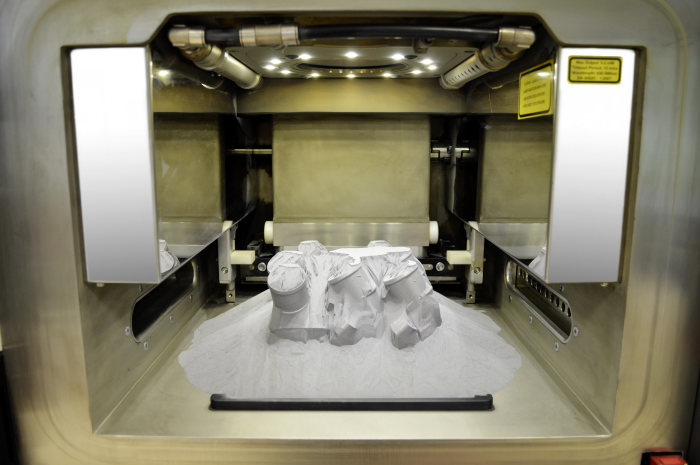 The working cavity of the SLM laser printer: as the work platform is raised, the powdered aluminium/silicon material moves to the side to reveal the contours of the thermostat covers. The working cavity of the SLM laser printer: as the work platform is raised, the powdered aluminium/silicon material moves to the side to reveal the contours of the thermostat covers.