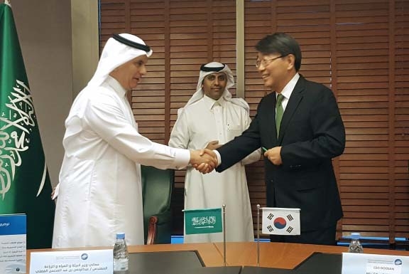 Saudi Arabia’s Minister of Environment Water and Agriculture shake hands with Yoon Seok-won, VP of Doosan Heavy Industries, and after signing the construction contract. Saudi Arabia’s Minister of Environment Water and Agriculture shake hands with Yoon Seok-won, VP of Doosan Heavy Industries, and after signing the construction contract.
