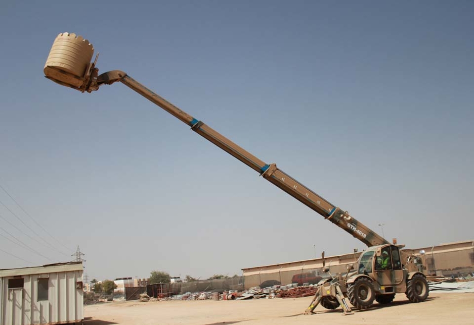 The custom livery Genie GTH-4018 telehandler lifts a water tank at its full horizontal reach of 13.36m in the Sultan of Omans Engineers equipment park. The custom livery Genie GTH-4018 telehandler lifts a water tank at its full horizontal reach of 13.36m in the Sultan of Omans Engineers equipment park.