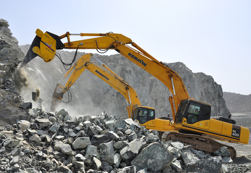 Two Komatsu Pc400s lay into a rock face with Xcentric rippers hydraulic breaker attachments. Two Komatsu Pc400s lay into a rock face with Xcentric rippers hydraulic breaker attachments.