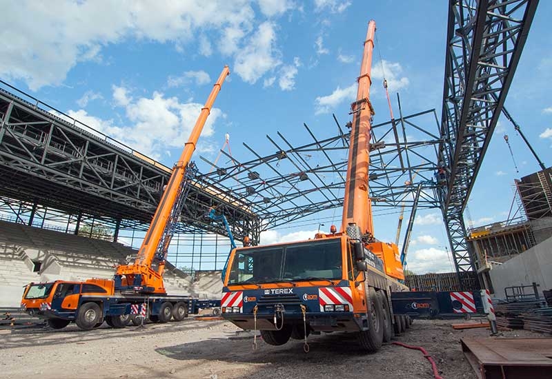 A Terex Explorer 5800 and Terex AC 250-1 tandem lift a pre-fabricated steel roof structure into place. A Terex Explorer 5800 and Terex AC 250-1 tandem lift a pre-fabricated steel roof structure into place.