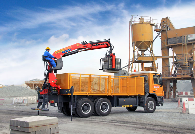 A truck equipped with a flat-bed body and a rear-mounted Palfinger knuckle-boom loader crane. A truck equipped with a flat-bed body and a rear-mounted Palfinger knuckle-boom loader crane.