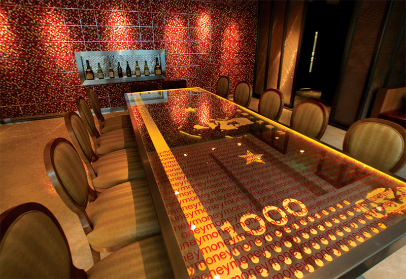 The private dining room features a glass table imprinted with a Chairman Mao 1000RMB note. The private dining room features a glass table imprinted with a Chairman Mao 1000RMB note.