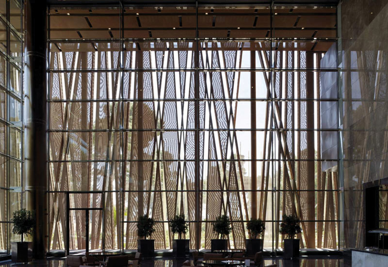 The building's perimeter is covered with a bronze mesh, which is decorated with patterns inspired by the trees that surround the site. The building's perimeter is covered with a bronze mesh, which is decorated with patterns inspired by the trees that surround the site.
