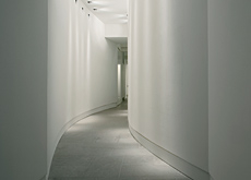A subtly lit winding corridor by Flos. A subtly lit winding corridor by Flos.